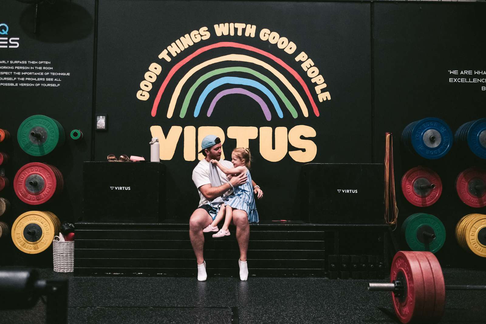 A dad and his little one under the Good Things With Good People wall